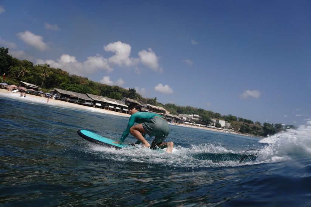 Men riding waves at Balangan Beach (Bukit Peninsula): Scenic Sands & Mellow Whitewash