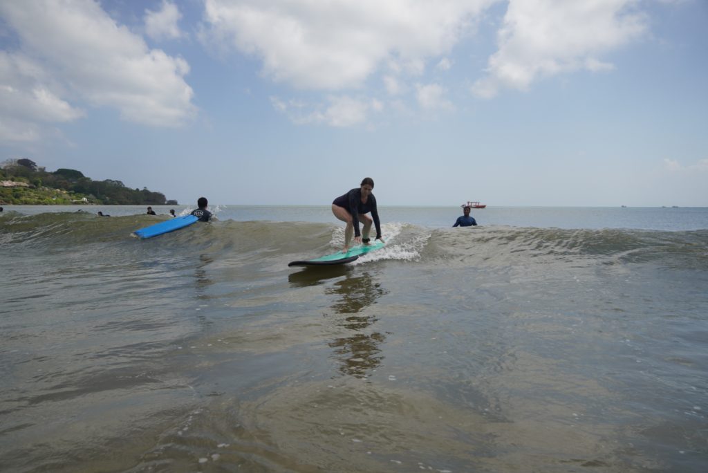 A woman quickly progresses from a first-time surfer to standing on her board at Muaya Beach, Jimbaran.