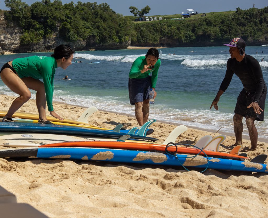 Surf Journey Instructor give basic surf lesson of paddling and the pop-up movement on the sand.